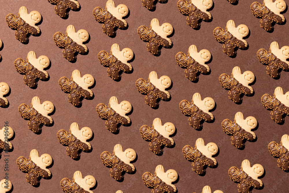 Pattern of gingerbread cookies dipped in chocolate on brown background