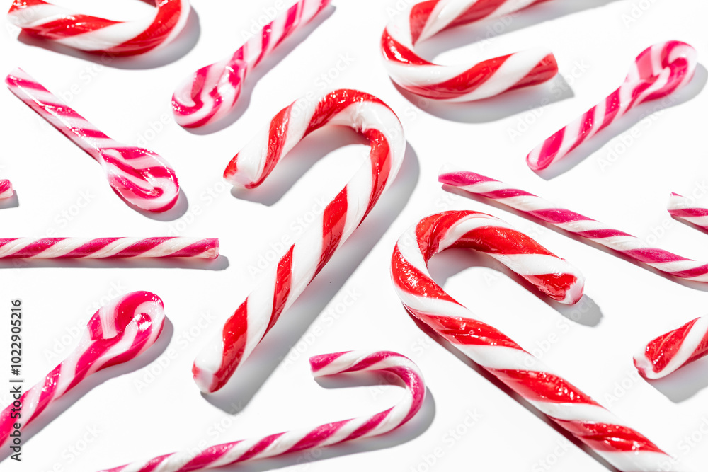 Top view of assorted red and white candy canes on white background