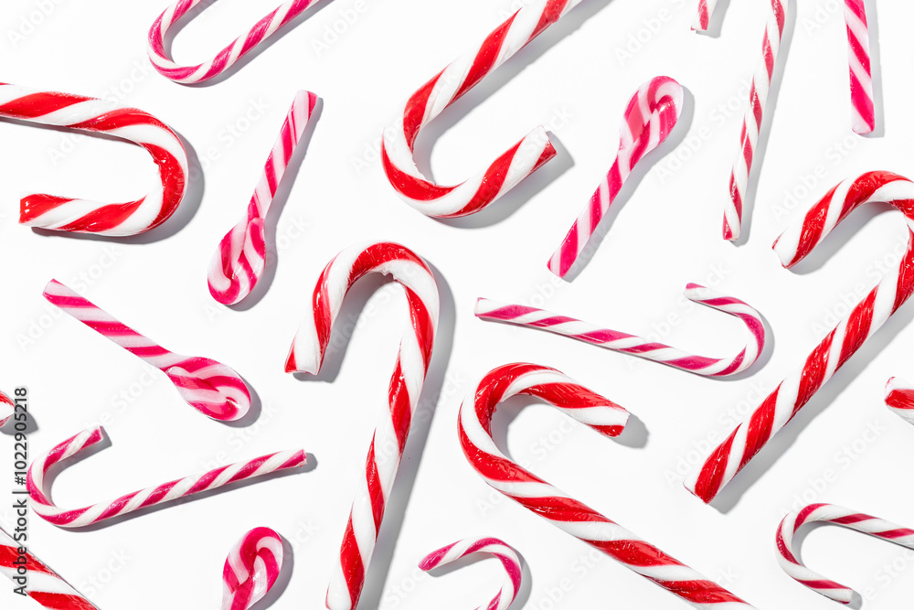 Top view of assorted red and white candy canes on white background