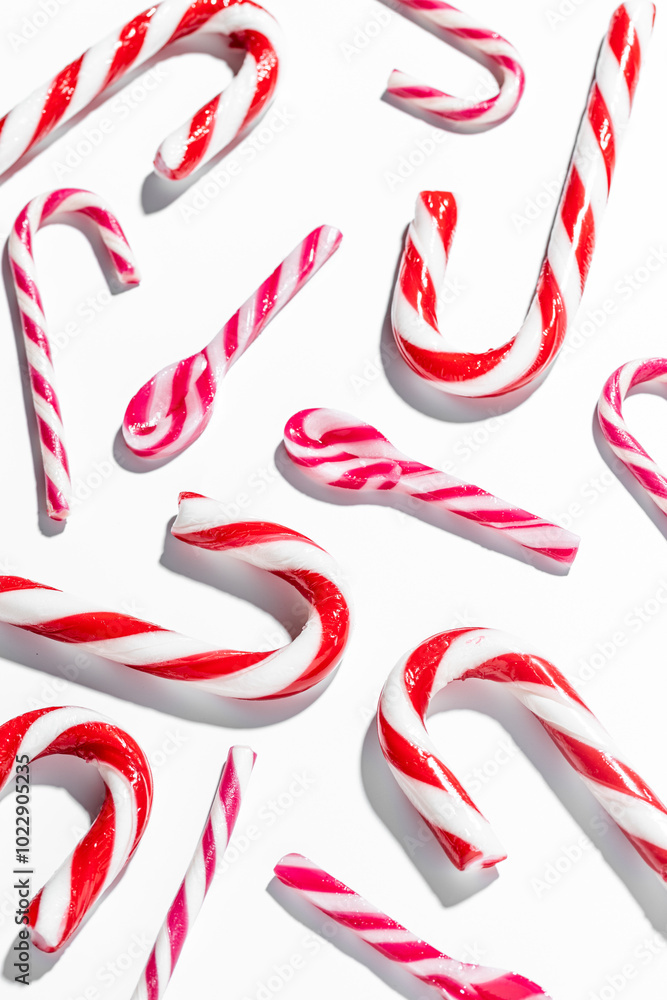 Top view of assorted red and white candy canes on white background