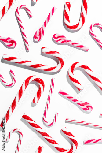 Top view of assorted red and white candy canes on white background vertical composition