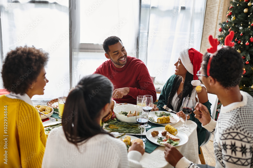 A group of friends gathers around the dining table to enjoy a festive Christmas meal. A group of friends gathers around the dining table to enjoy a festive Christmas meal.