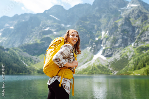 Young woman with backpacker enjoys beautiful nature while standing on top of the hill. Eco tourism. Travel, adventure.