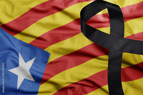 waving national flag of catalonia with black mourning ribbon .tragedy concept