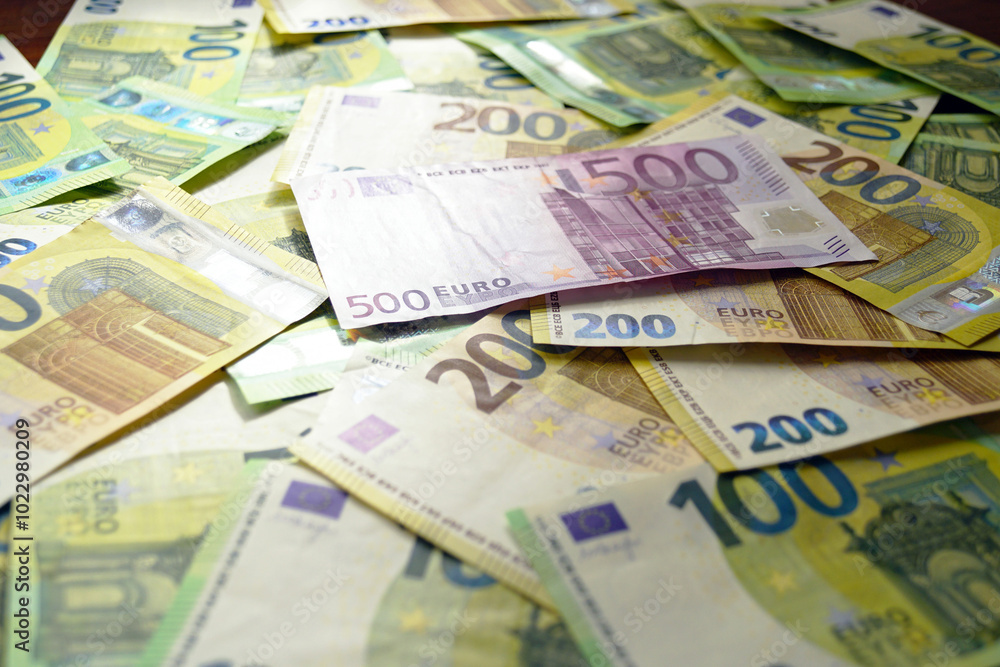 Several thousand euros in paper money: 500, 200 and 100 euro notes spread out on a surface. The savings of a citizen of the European Union, kept in cash.
