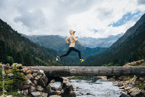 Woman trail runner cross country running in high altitude mountains photo