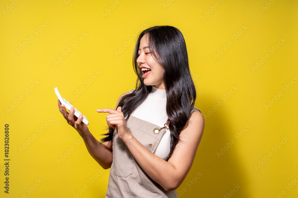 A woman is holding a cell phone and pointing at it A woman is holding a cell phone and pointing at it