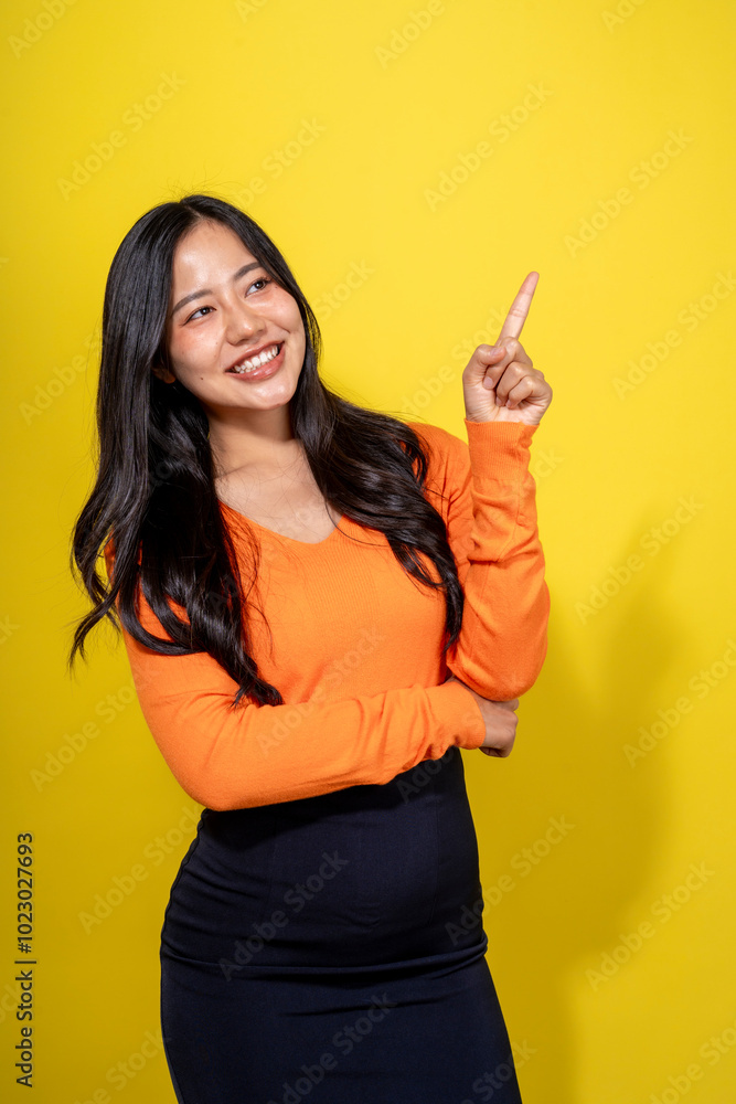 A woman in an orange shirt and black skirt is pointing to the camera A woman in an orange shirt and black skirt is pointing to the camera