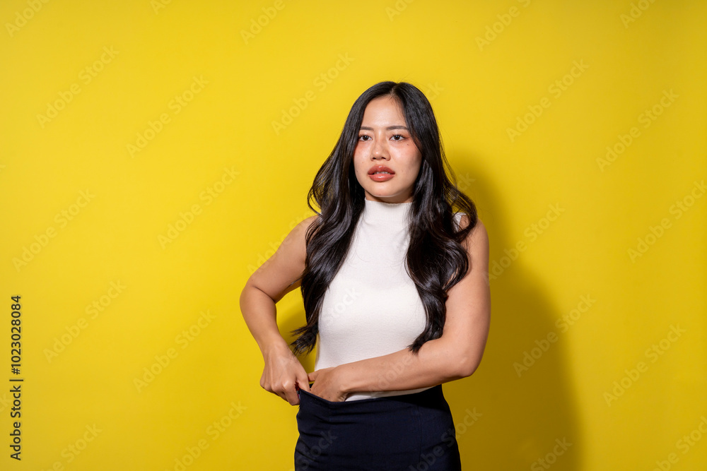 A woman with long hair is standing in front of a yellow wall A woman with long hair is standing in front of a yellow wall