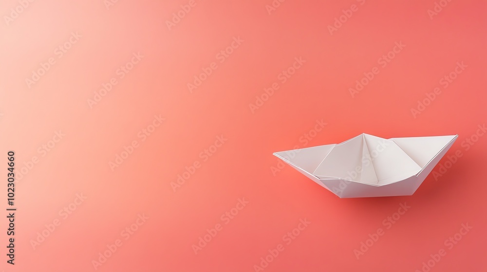 A white paper boat on a pink background. A white paper boat on a pink background.