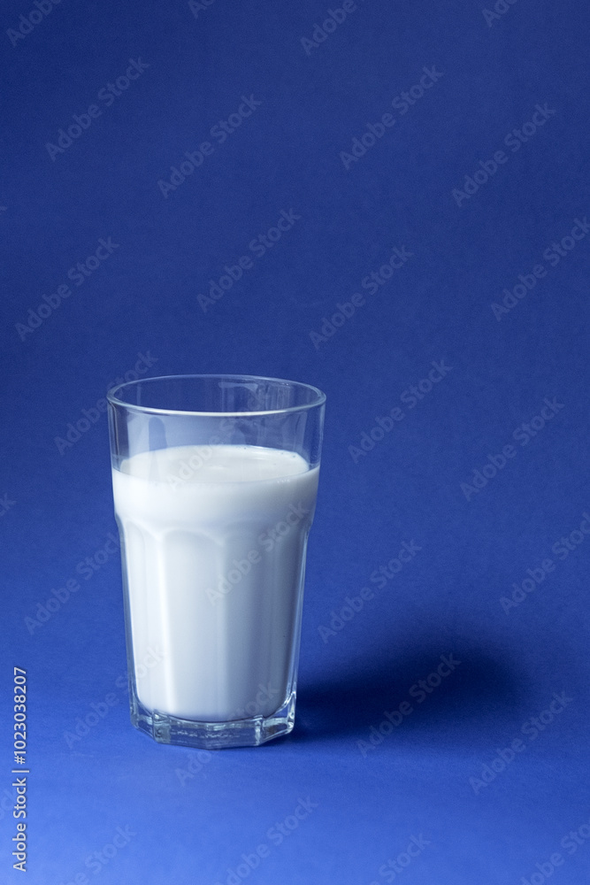 Fresh milk in a glass on blue surface Fresh milk in a glass on blue surface