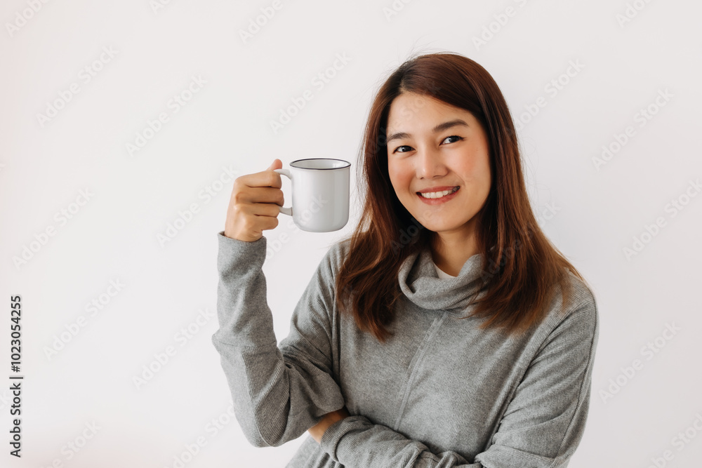 Happy asian woman holding and showing white cup with smiling face in winter, drinking hot water coffee, making warm, isolated over white background wall. Happy asian woman holding and showing white cup with smiling face in winter, drinking hot water coffee, making warm, isolated over white background wall.