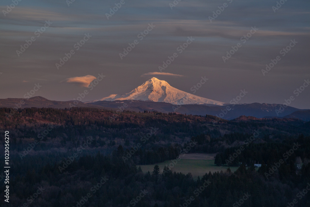 Fototapeta premium Beautiful sunset at Oregon's icon Mount Hood. Golden hour sunlight showing off the snow peak. High quality picture for download.