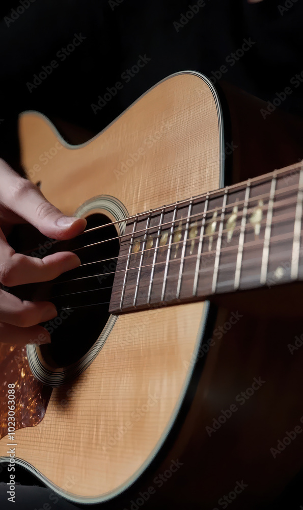 Fototapeta premium Close-up of fingers strumming an acoustic guitar