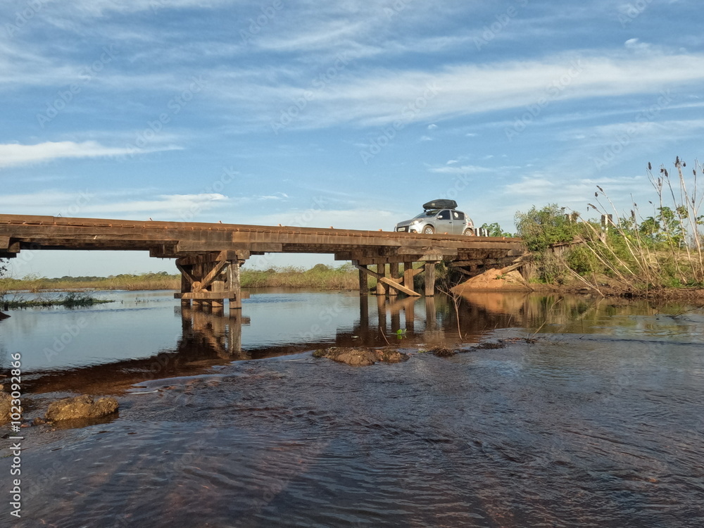 Naklejka premium carro em ponte de madeira na estrada parque pantanal no mato grosso dos ul 