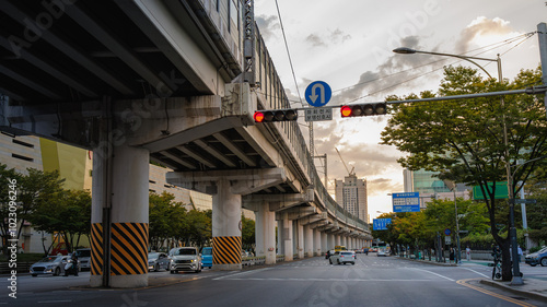 A street scene in Seoul with an elevated railway running through the middle of the road photo