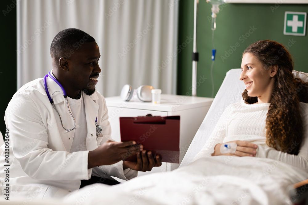 African doctor sits with a folder, discussing details with the red-haired patient. African doctor sits with a folder, discussing details with the red-haired patient.
