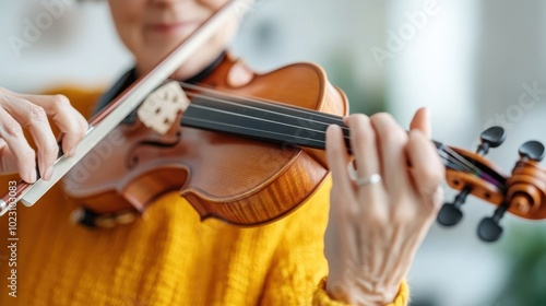 A person elegantly dressed in a yellow sweater focuses on playing a violin, capturing the intimate and expressive moment of music creation in an indoor setup.