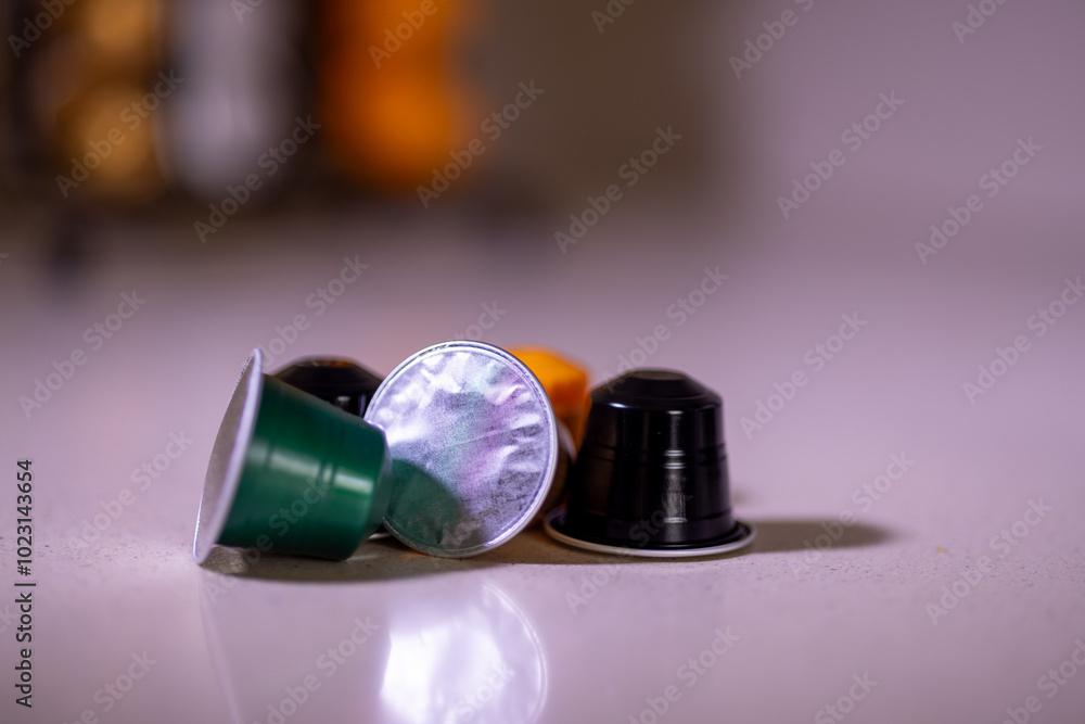 Close-up of colorful coffee capsules with a modern capsule organizer visible in the background Close-up of colorful coffee capsules with a modern capsule organizer visible in the background