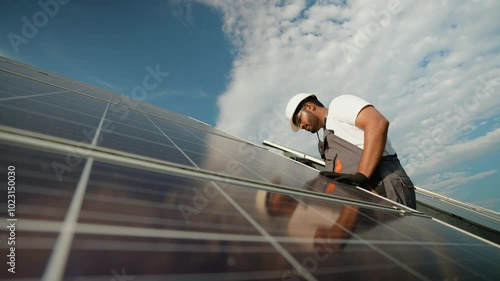 Indian technician performing solar panel maintenance outdoors