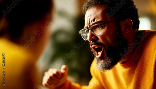 A man passionately argues while wearing a bright sweater, showcasing intense emotions and engagement in a heated discussion. photo