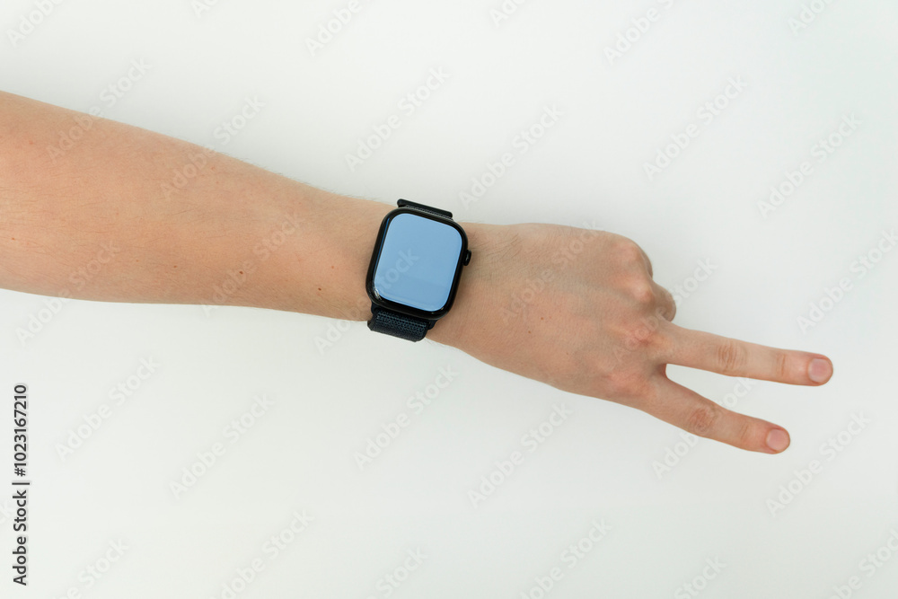 Fototapeta premium Young Male arm wearing and showing black smartwatch with blank screen isolated