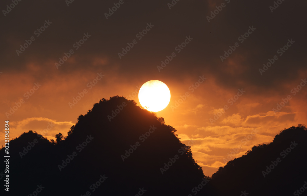 Vibrant sunset with orange sky over silhouette mountain Vibrant sunset with orange sky over silhouette mountain