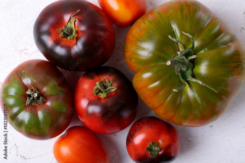 Fototapeta premium Assorted tomatoes of different colors and sizes. Top view. Food background