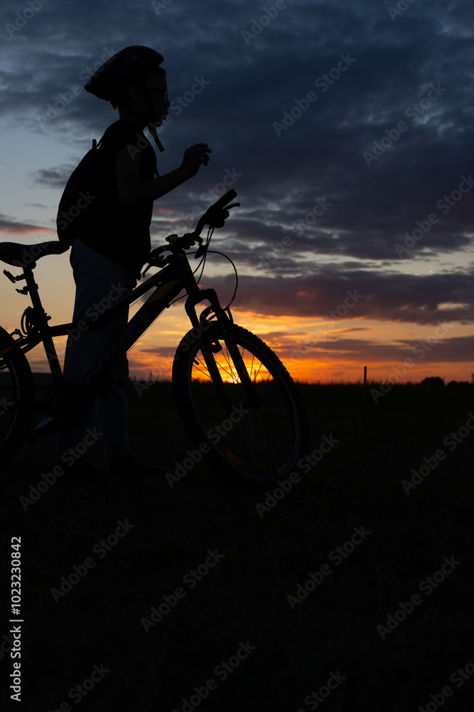 Silhouette of a cyclist with a bicycle against a beautiful sunset sky, conveying the essence of outdoor adventure and active lifestyle. . High quality photo Silhouette of a cyclist with a bicycle against a beautiful sunset sky, conveying the essence of outdoor adventure and active lifestyle. . High quality photo