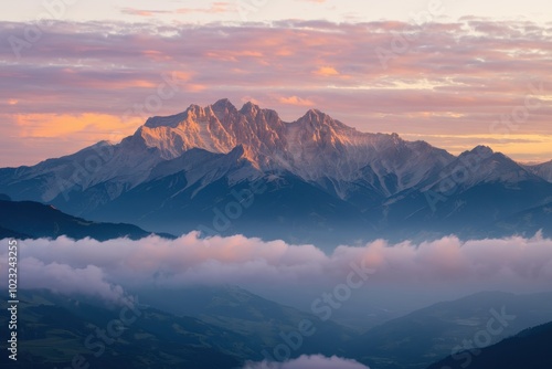 The mountain range is covered in snow and the sky is a beautiful pink color