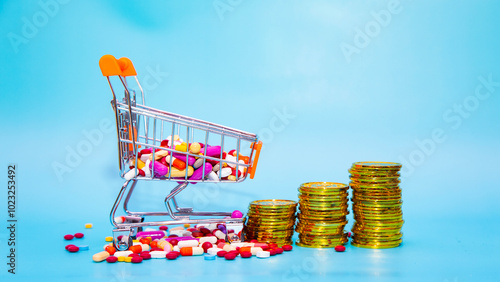 Colourful multiple pills and capsules are in trolley shopping cart with a pile of gold coins on blue background. Concept of business, Buy and shopping, medical science, pharmaceutical, healthcare.
