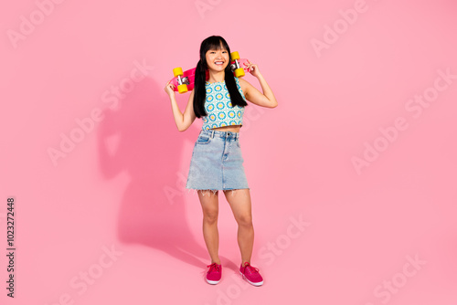 Photo of lovely cute nice girl wear stylish clothes hold skate board isolated on pink color background