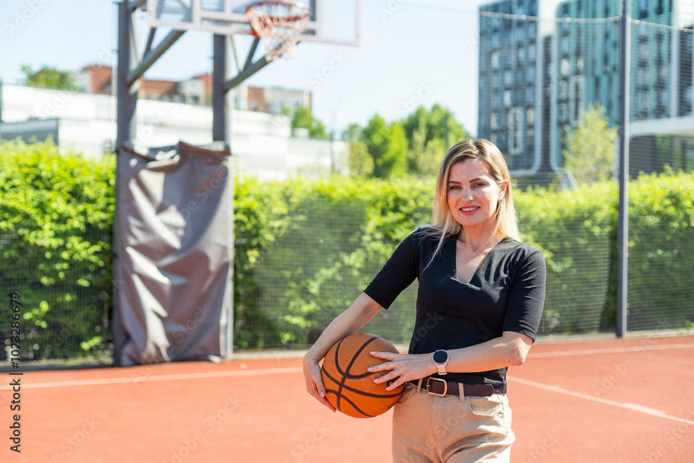 Young sports girl with a basketball on the basketball court outdoors, active weekend. Young sports girl with a basketball on the basketball court outdoors, active weekend.