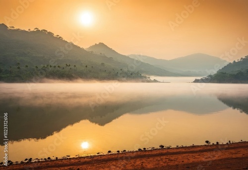 An early morning shot of Banasura Sagar, with fog rising from the water and sunlight streaming through photo