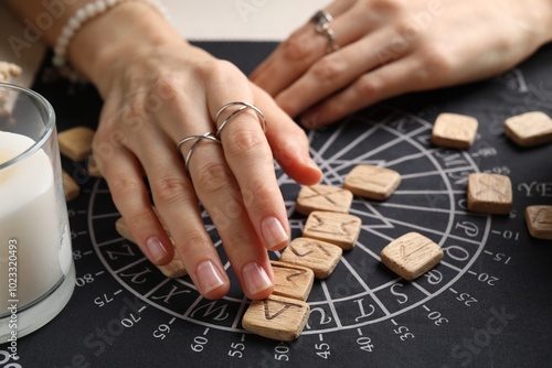 Woman with wooden runes at table, closeup photo