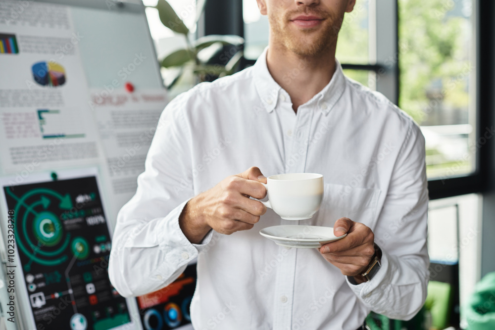 A focused redhead businessman sips coffee, deep in thought about a project in his stylish office. A focused redhead businessman sips coffee, deep in thought about a project in his stylish office.