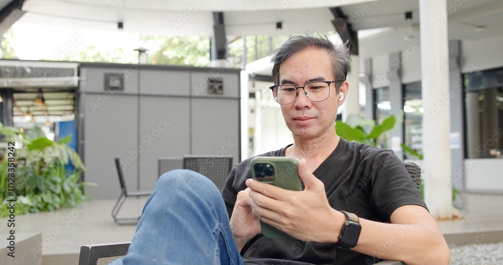 Asian Middle-aged man using smartphone to shop online. Senior make financial transactions, transfer money via bank apps, order products. Businessman chatting on mobile phone. communication technology Asian Middle-aged man using smartphone to shop online. Senior make financial transactions, transfer money via bank apps, order products. Businessman chatting on mobile phone. communication technology