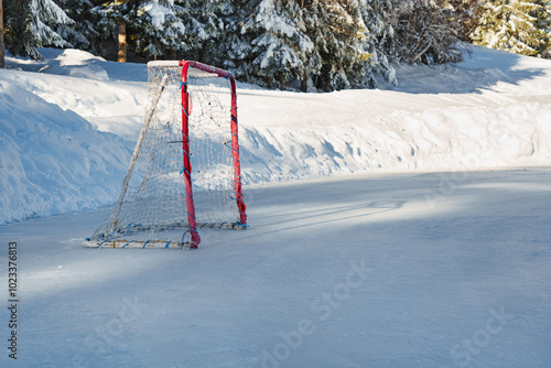 An ice hockey goal on a frozen lake in the mountains on the scratches surface abstract background ice arena