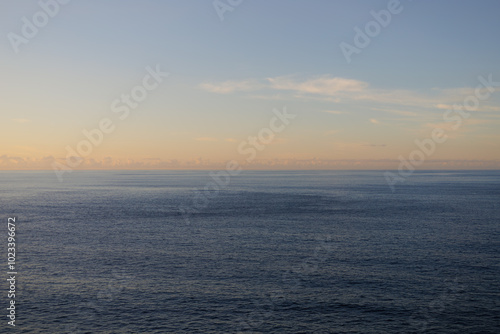 Sunset sky over the Atlantic Ocean, Tenerife. Minimalism. Misty morning in the sea. Calm view. Tranquil empty landscape with soft warm blue and gold pink sky. Natural dusk weather.