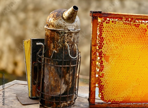 Obraz na płótnie an old smoker to calm bees and a honeycomb w salonie