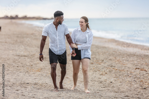 A couple strolls hand in hand along the sandy beach of Zapillo, Almeria, enjoying a peaceful moment by the shoreline