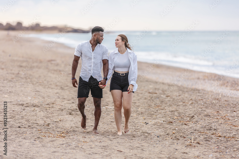 A couple walks hand in hand along the serene beach of Zapillo in Almeria, Spain, enjoying a peaceful moment by the sea A couple walks hand in hand along the serene beach of Zapillo in Almeria, Spain, enjoying a peaceful moment by the sea