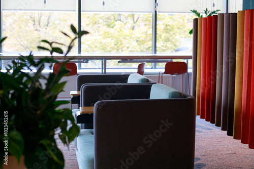 Bright and inviting workspace featuring comfortable chairs, vibrant fabric panels, and abundant natural light.