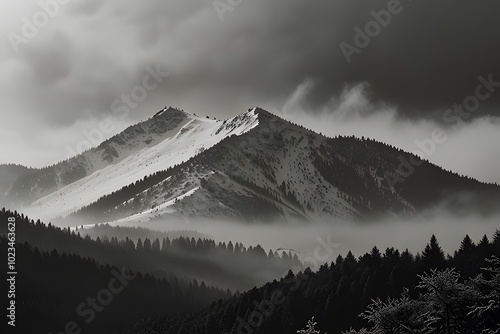 snow-covered mountain range partially shrouded in mist and fog photo