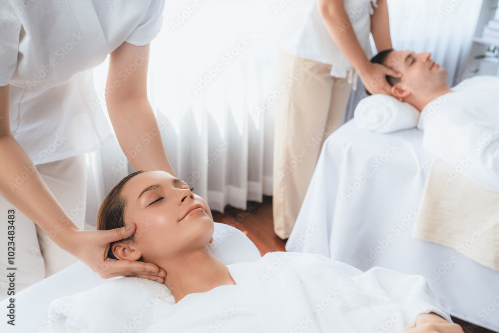 Obraz premium Caucasian couple enjoying relaxing anti-stress head massage and pampering facial beauty skin recreation leisure in dayspa modern light ambient at luxury resort or hotel spa salon. Quiescent