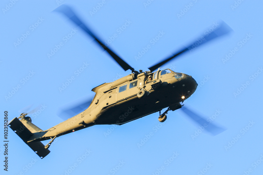 Fototapeta premium Military Helicopter Flying in Clear Blue Sky During Daytime, Showcasing Tactical Design and Maneuverability