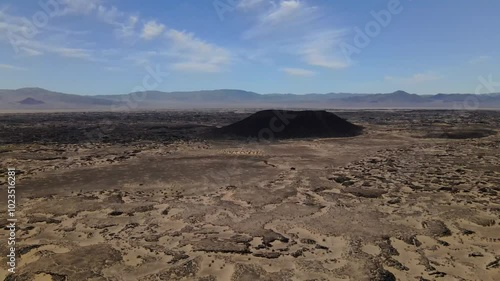Wallpaper Mural Aerial drone footage of a black lava crater in the middle of an arid desert under a blue sky in California, USA Torontodigital.ca