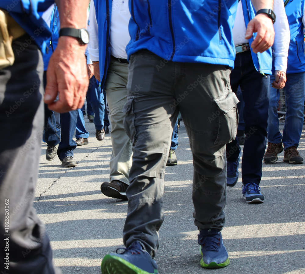 legs of striking workers marching on the street during a peaceful protest to increase factory worker wages legs of striking workers marching on the street during a peaceful protest to increase factory worker wages