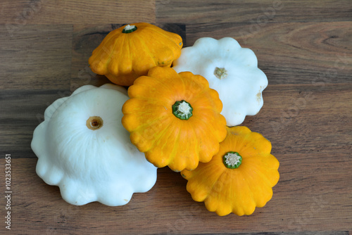 a group of pumpkins with a white squash on a wooden surface  