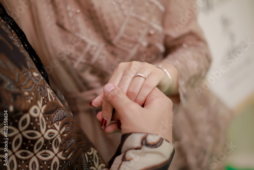 Close up of couple's hands holding each other. Indonesian proposal procession. Illustration of love